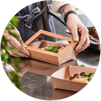 En man förpackar mat i en engångsförpackning